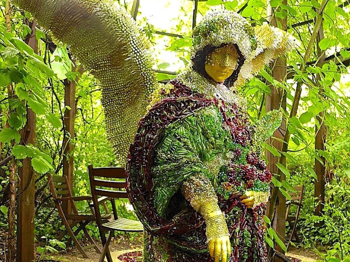 Engel-Skulptur im Vortex Garten Darmstadt, umgeben von kunstvoll gestalteter Gartenlandschaft.